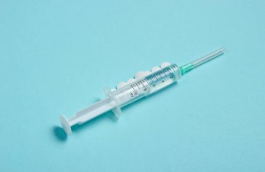 Mavi arka planda tıbbi hayat. Şırınga, hap. Minimalizm