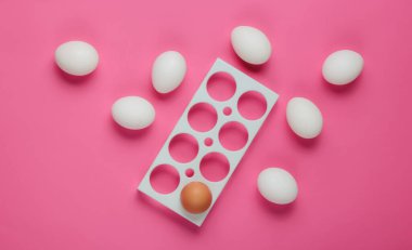 Boş tepsi ve pembe arka planda tavuk yumurtası. Minimalizm gıda konsepti. Üst görünüm