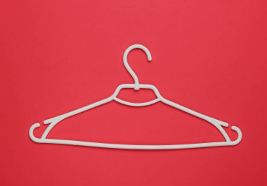 Kırmızı kağıtta plastik askı. Minimalist moda konsepti. Üst görünüm