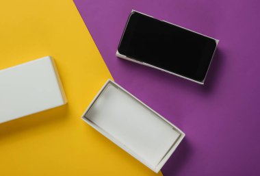 Renkli arka planda yeni modern akıllı telefon kutusu. Minimalist moda konsepti, hediye