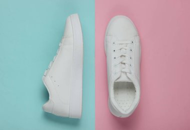 Pembe mavi pastel arka planda şık beyaz ayakkabılar. Üst görünüm