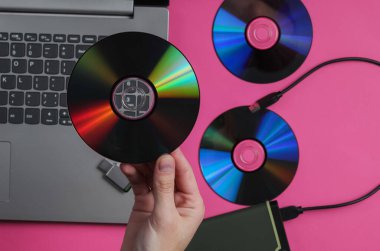 Bir kadın CD sürücülerini arka planda tutuyor. Üst görünüm