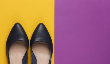 Klasik kadın topuklu ayakkabıları. Renkli kâğıt arka planda. Şık ayakkabılar. Minimalist moda natürmort.