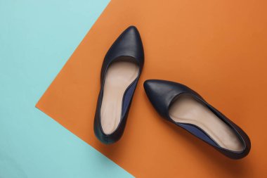 Klasik kadın yüksek topuklu ayakkabıları, mavi kahverengi kağıttan arka planda. Şık ayakkabılar. Minimalist moda natürmort.