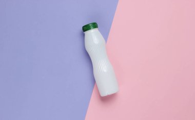 Pastel kağıdın üzerinde yoğurt şişesi. Üst görünüm