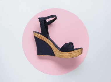 Beyaz arka planda platformu olan şık bir kadın sandaleti ve ortasında pembe bir daire. Şık ayakkabılar. Minimalist moda hala hayattadır. Üst görünüm