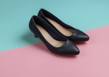 Pastel pembe-mavi arka planda klasik yüksek topuklu deri ayakkabılar. Minimalist moda hala hayattadır. Stüdyo çekimi