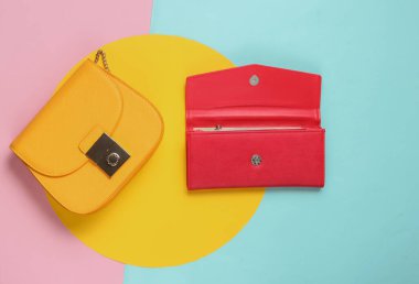 Sarı deri çanta ve pastel arka planda kırmızı cüzdan. Üst Manzara. Minimalist moda konsepti.