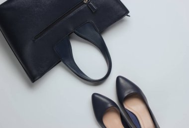 Klasik yüksek topuklu ayakkabılar, beyaz arka planda deri çanta. Minimalizm moda kavramı. Üst görünüm