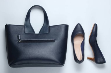Klasik yüksek topuklu ayakkabılar, beyaz arka planda deri çanta. Minimalizm moda kavramı. Üst görünüm