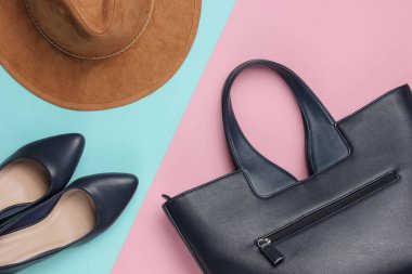 Keçeli şapka, yüksek topuklu ayakkabılar, pembe mavi pastel arka planda deri çanta. Minimalist moda konsepti. Üst görünüm