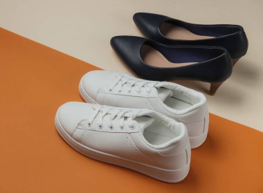 Deri yüksek topuklu ayakkabılar ve renkli arka planda spor ayakkabılar. Minimalist moda konsepti. Stüdyo çekimi