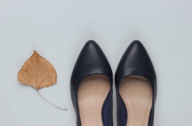 Sonbahar koleksiyonu. Deri yüksek topuklu ayakkabılar ve arka planda kuru sonbahar yaprağı. Stüdyo çekimi. Üst görünüm