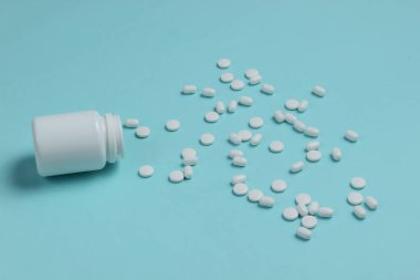 Mavi arka planda hapları olan bir şişe. Tıbbi hayat