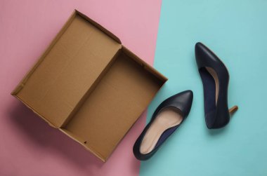 Mavi-pembe pastel arka planda karton kutulu yeni deri ayakkabılar. Kadın için bir hediye. Üst görünüm