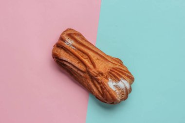 Mavi-pembe renkli arka planda bir ekler. Minimalist yiyecekler hala hayattadır. Üst görünüm