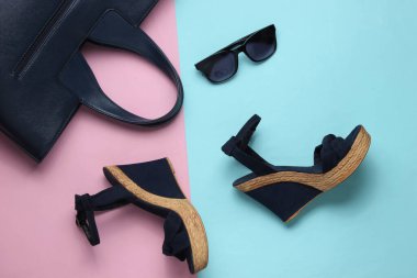 Platformlu kadın sandaletleri, pastel arka planda güneş gözlükleri. Kadın yaz ayakkabıları ve aksesuarları. Üst görünüm.