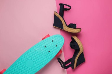 Yaz eğlencesi. Pembe stüdyo arka planında kruvazör tahtasıyla platformda kadın sandaletleri. Moda çekimi, üst manzara.