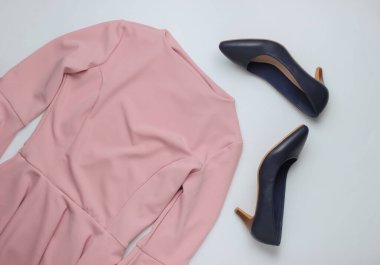 Düz stil kadın kıyafetleri, beyaz arka planda aksesuarlar. Pembe elbise, yüksek topuklu deri ayakkabılar. Üst görünüm