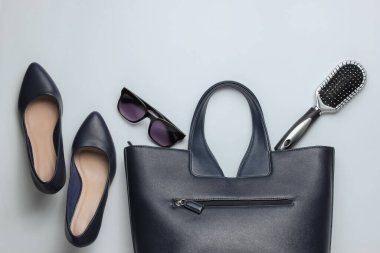 Düz kadın ayakkabıları, beyaz arka planda aksesuarlar. Çanta, yüksek topuklu ayakkabı, güneş gözlüğü, tarak. Üst görünüm