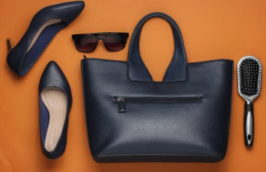 Çantada ne var? Kadın aksesuarları, kahverengi arka planda ayakkabılar. Üst görünüm, minimalizm