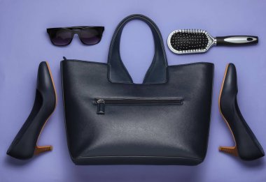 Mor arka planda düz stil kadın aksesuarları. Çanta, yüksek topuklu ayakkabı, güneş gözlüğü, tarak. Üst görünüm