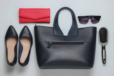 Çantada ne var? Kadın aksesuarları, beyaz arka planda ayakkabılar. Üst görüş, minimalizm. Güzellik ve moda