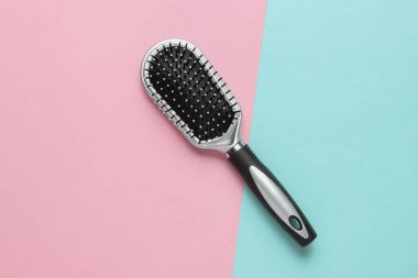 Pembe mavi pastel arka planda şık bir saç fırçası. Kadın Saç Bakımı Aksesuarları. Üst görünüm