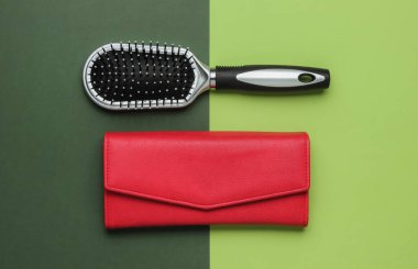 Modaya uygun kadın aksesuarları. Deri cüzdan, yeşil arka planda tarak. Üst görünüm