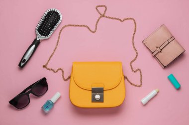 Çantada ne var? Kadın aksesuarları, pembe pastel arka planda ayakkabılar. Güzellik ve moda konsepti. Üst manzara, düz minimalizm