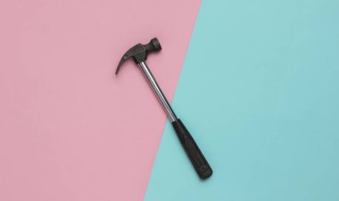 Mavi-pembe renkli arka planda çekiç. Üst görünüm, minimalizm