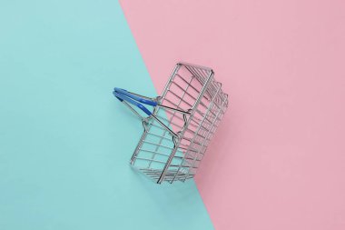 Mini alışveriş sepeti pembe mavi pastel arka planda. Üst görünüm