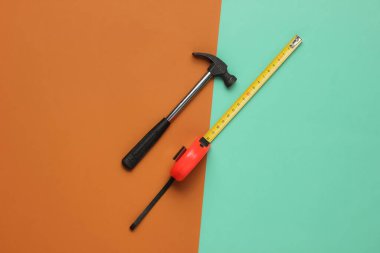 Kahverengi mavi arka planda çekiç ve cetvel. Üst görünüm, minimalizm