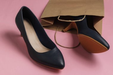 Alışveriş konsepti. Moda stüdyosu çekimi. Pembe pastel arka planda alışveriş yapmak için kadın yüksek topuklu ayakkabıları. Üst görünüm