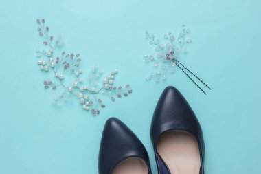 Gelinin ücreti, düğün günü. Gelinin saçında süsleme, mavi renkli arka planda yüksek topuklu ayakkabılar.