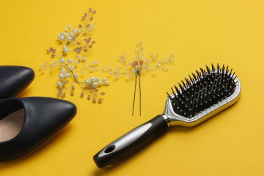 Gelinin ücreti, düğün günü. Gelinin saçında süsleme, tarak, sarı arka planda yüksek topuklu ayakkabılar.