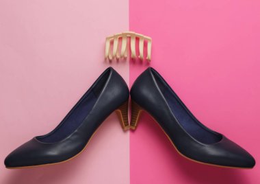 Asgari güzellik ve moda konsepti. Kadın aksesuarları. Yüksek topuklu ayakkabılar, pembe arka planda saç tokası. Üst görünüm