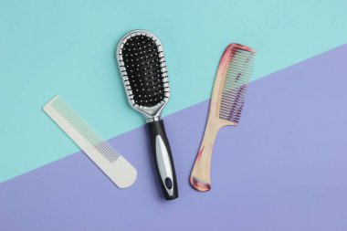 Mavi-mor pastel arka planda taraklar. Güzellik minimalist konsepti. Saç bakımı. Üst görünüm