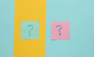 Renkli arka planda soru işaretleri olan not kağıtları. Üst görünüm