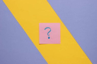 Renkli arka planda soru işareti olan not kağıtları. Üst görünüm