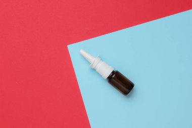 Renkli bir arka planda burun akıntısına karşı burun spreyi. Tıbbi mini natürmort