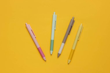 Sarı arkaplanda bir sürü renkli kalem var..