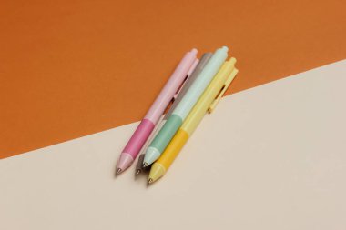 Kahverengi bej arka planda bir sürü renkli kalem var..