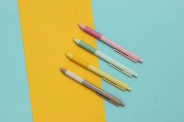 Sarı arkaplanda bir sürü renkli kalem var..