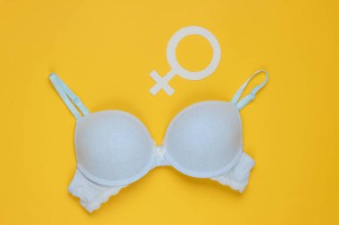 Sarı arka planda Femen iç çamaşırı ve cinsiyet sembolü. Feminizm kavramı.