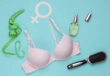 Mavi arka planda sütyen ve kadın aksesuarları. Kadın giysisinin yukarıdan görünüşü. Moda kadın kıyafetleri. Düz yatış, üst görünüm.