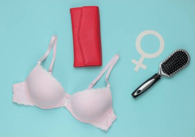 Mavi arka planda sütyen ve kadın aksesuarları. Kadın giysisinin yukarıdan görünüşü. Moda kadın kıyafetleri. Düz yatış, üst görünüm.