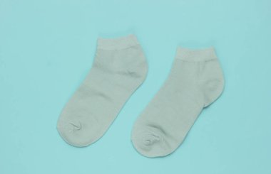 Mavi arka planda nane yeşili çoraplar. Pastel renk eğilimi. Üst görünüm