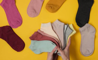 Stüdyonun sarı arka planında kadın çorapları tutuyor. Üst görünüm