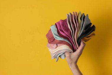 Stüdyonun sarı arka planında kadın çorapları tutuyor. Üst görünüm